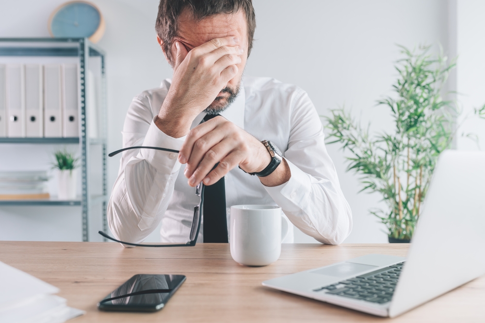 Businessman and entrepreneur realizing the big mistake he made, hand covering face in disbelief, selective focus